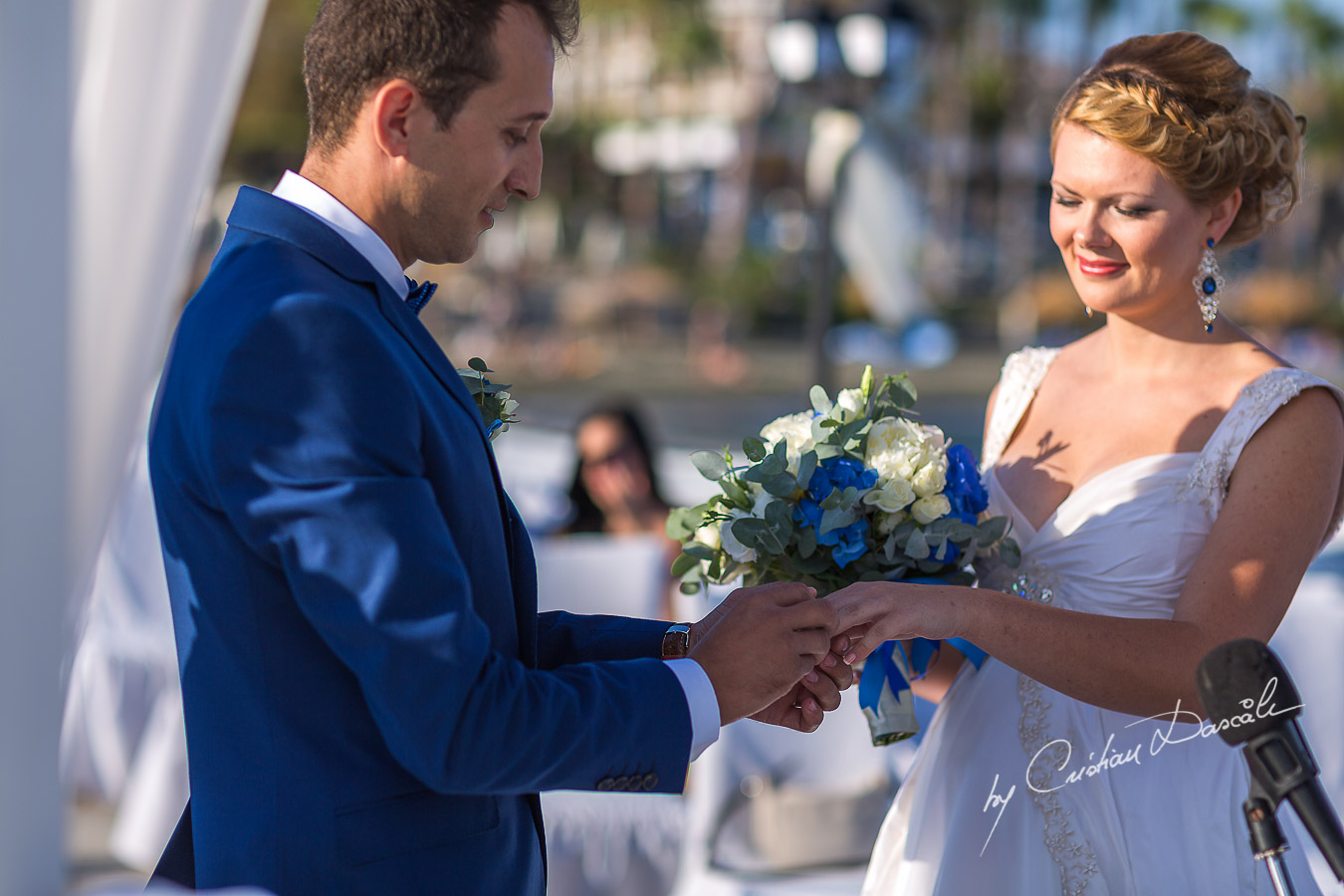 The groom is placing the ring on Daria`s finger