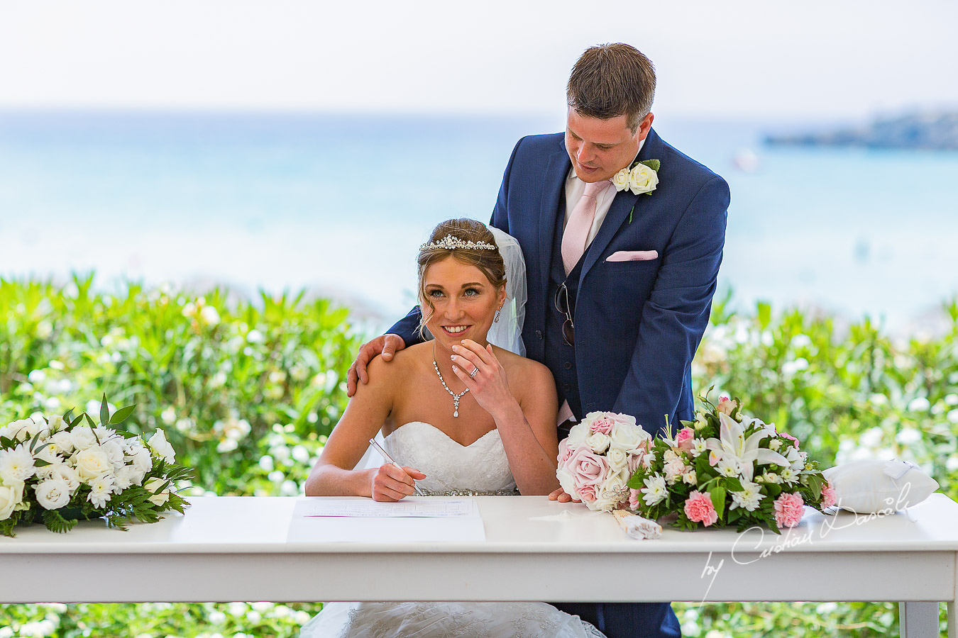 Bride Alicia signing her wedding certificate, moment photographed at Nissi Beach Resort in Ayia Napa, Cyprus by Cristian Dascalu.