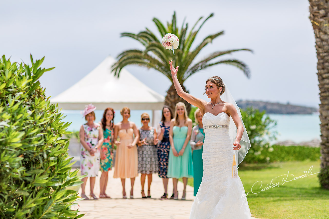 Alicia tossing the bouquet, moment photographed at Nissi Beach Resort in Ayia Napa, Cyprus by Cristian Dascalu.