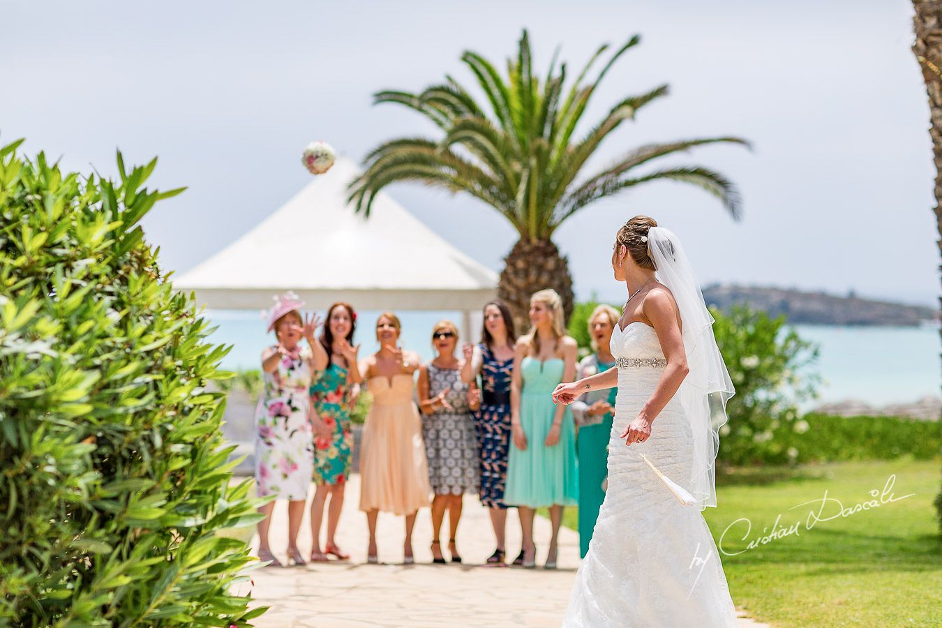 Alicia tossing the bouquet, moment photographed at Nissi Beach Resort in Ayia Napa, Cyprus by Cristian Dascalu.