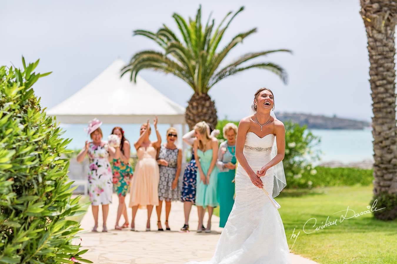 Alicia tossing the bouquet, moment photographed at Nissi Beach Resort in Ayia Napa, Cyprus by Cristian Dascalu.