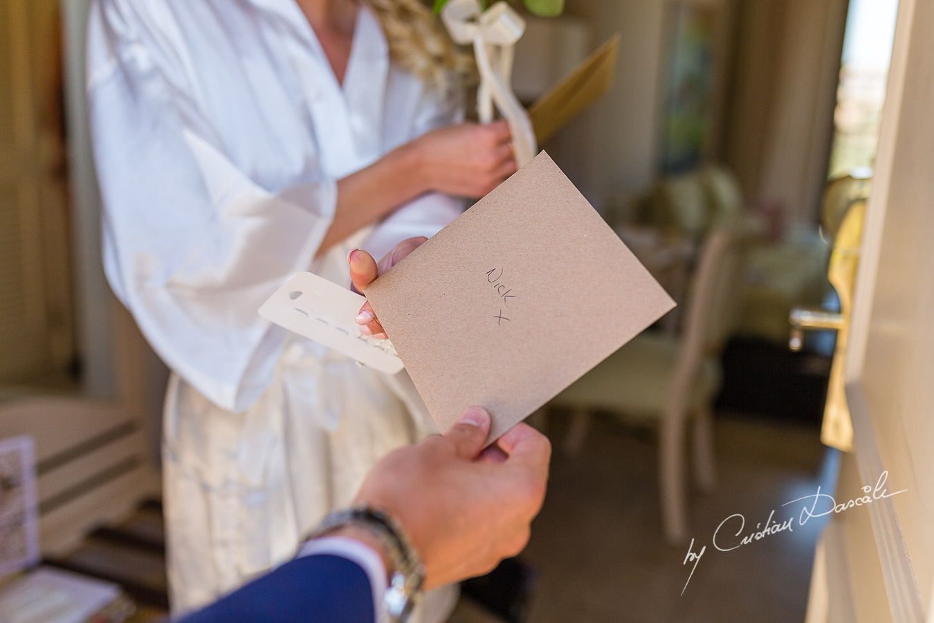 The Bride gives back to the Bestman an envelope for the Groom captured at Aphrodite Hills Resort before the wedding ceremony by Cristian Dascalu.