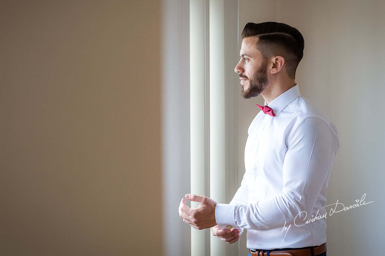 Groom's arranging his cufflinks photographed at a wedding in Nicosia by Cyprus Wedding Photographer Cristian Dascalu