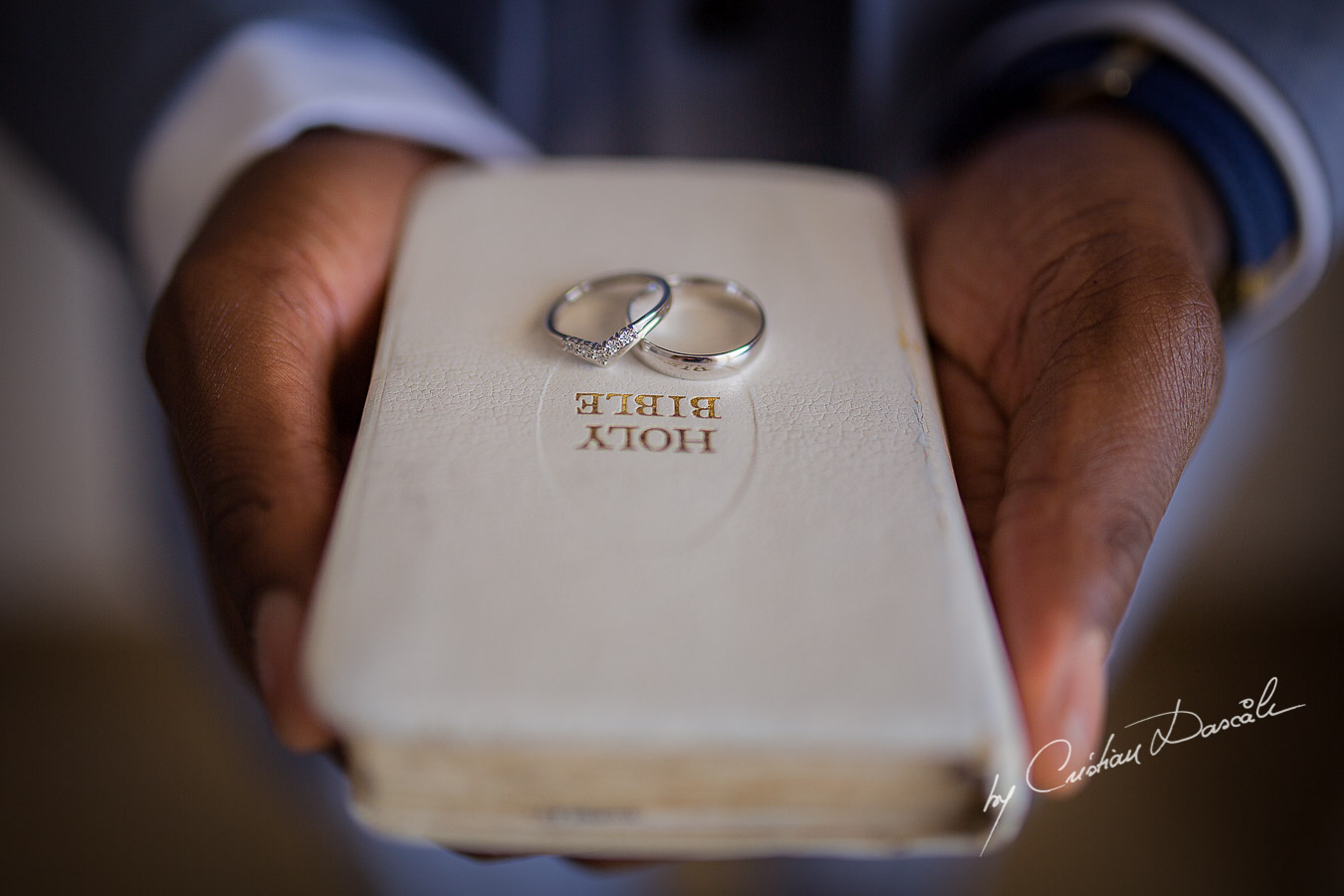 The wedding rings captured on the Holy Bible at a wedding at Minthis Hills in Cyprus, by Cristian Dascalu.