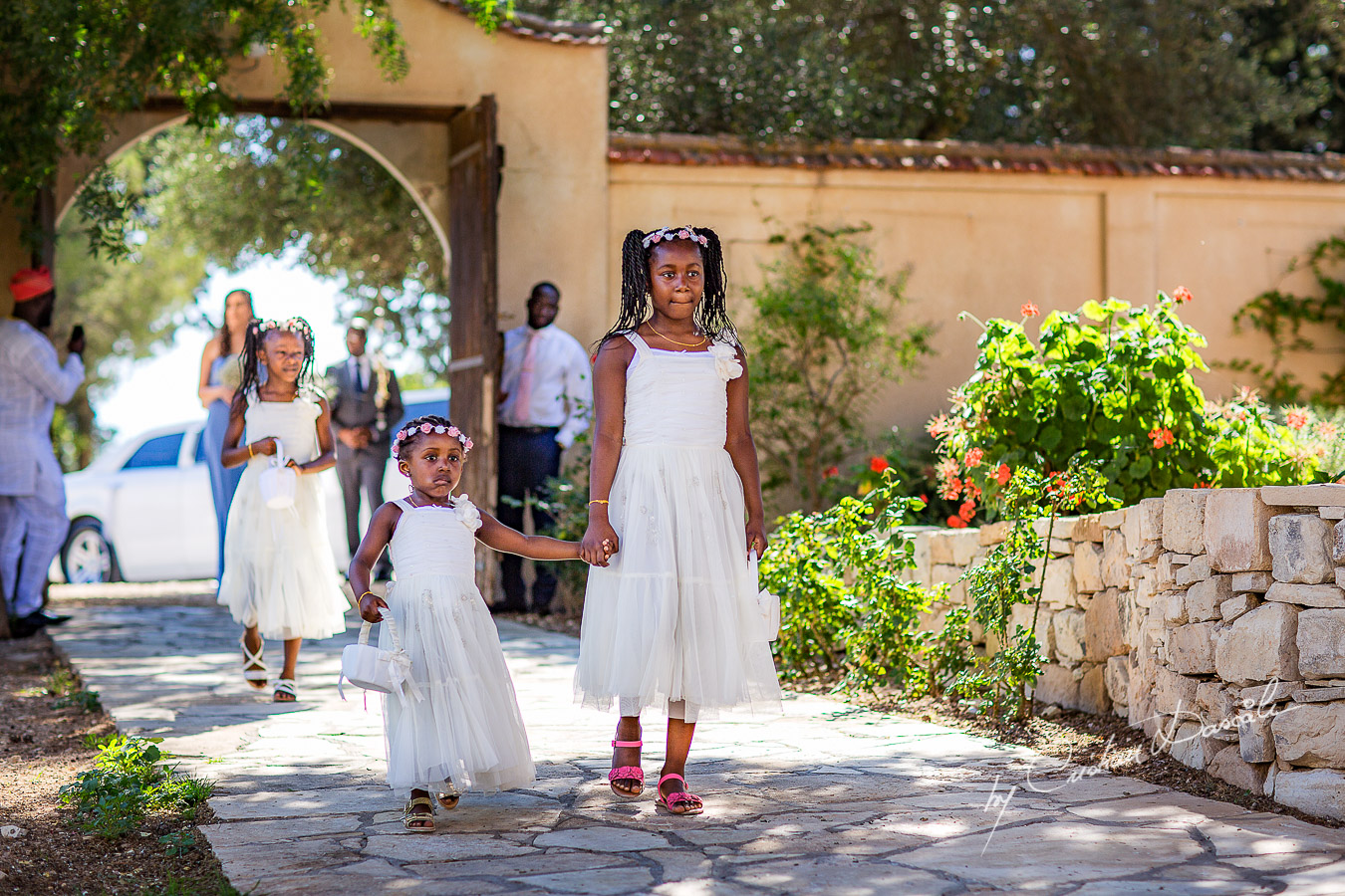 Moments with flower girls announcing the arrival of the bride captured a wedding at Minthis Hills in Cyprus, by Cristian Dascalu.