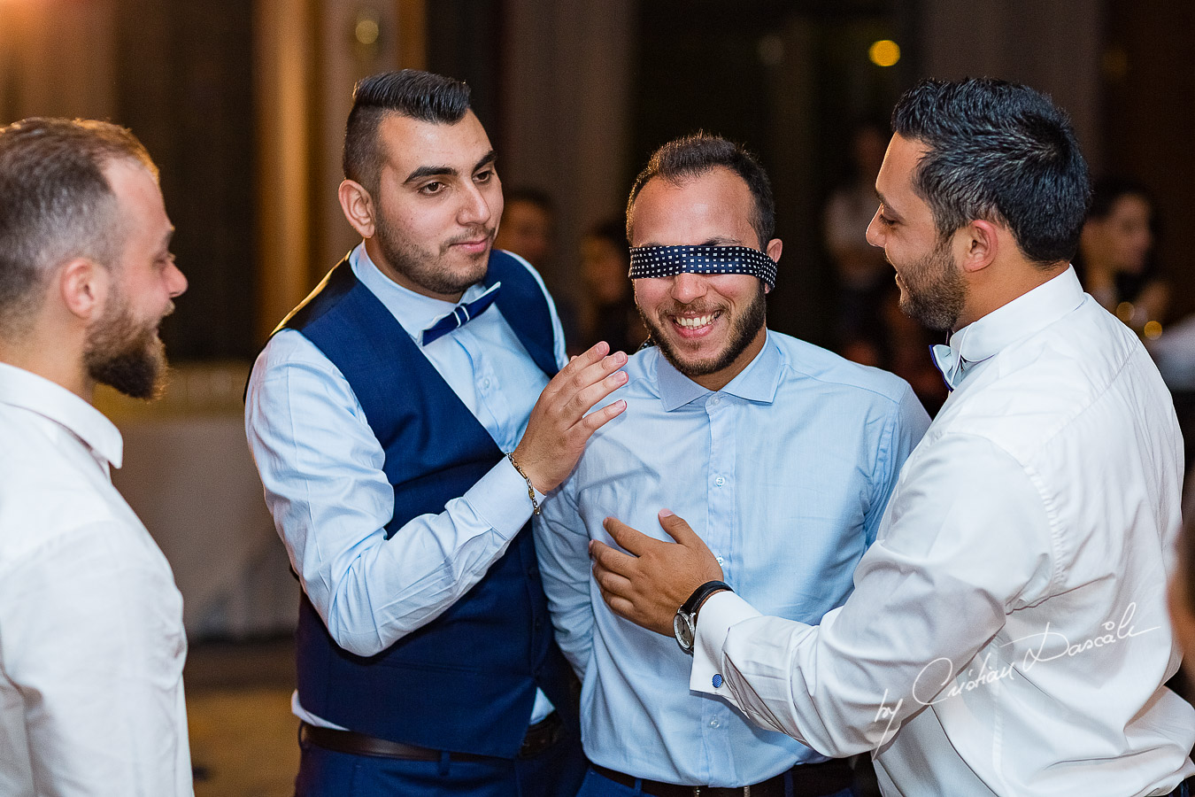 Moment when the groom is prepared for the garter photographed as part of an Exclusive Wedding photography at Grand Resort Limassol, captured by Cyprus Wedding Photographer Cristian Dascalu.