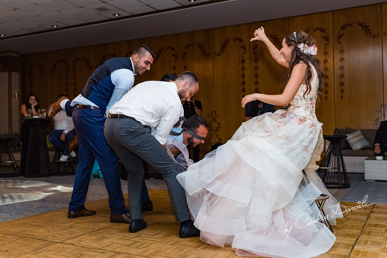Moment when the groom is prepared for the garter photographed as part of an Exclusive Wedding photography at Grand Resort Limassol, captured by Cyprus Wedding Photographer Cristian Dascalu.