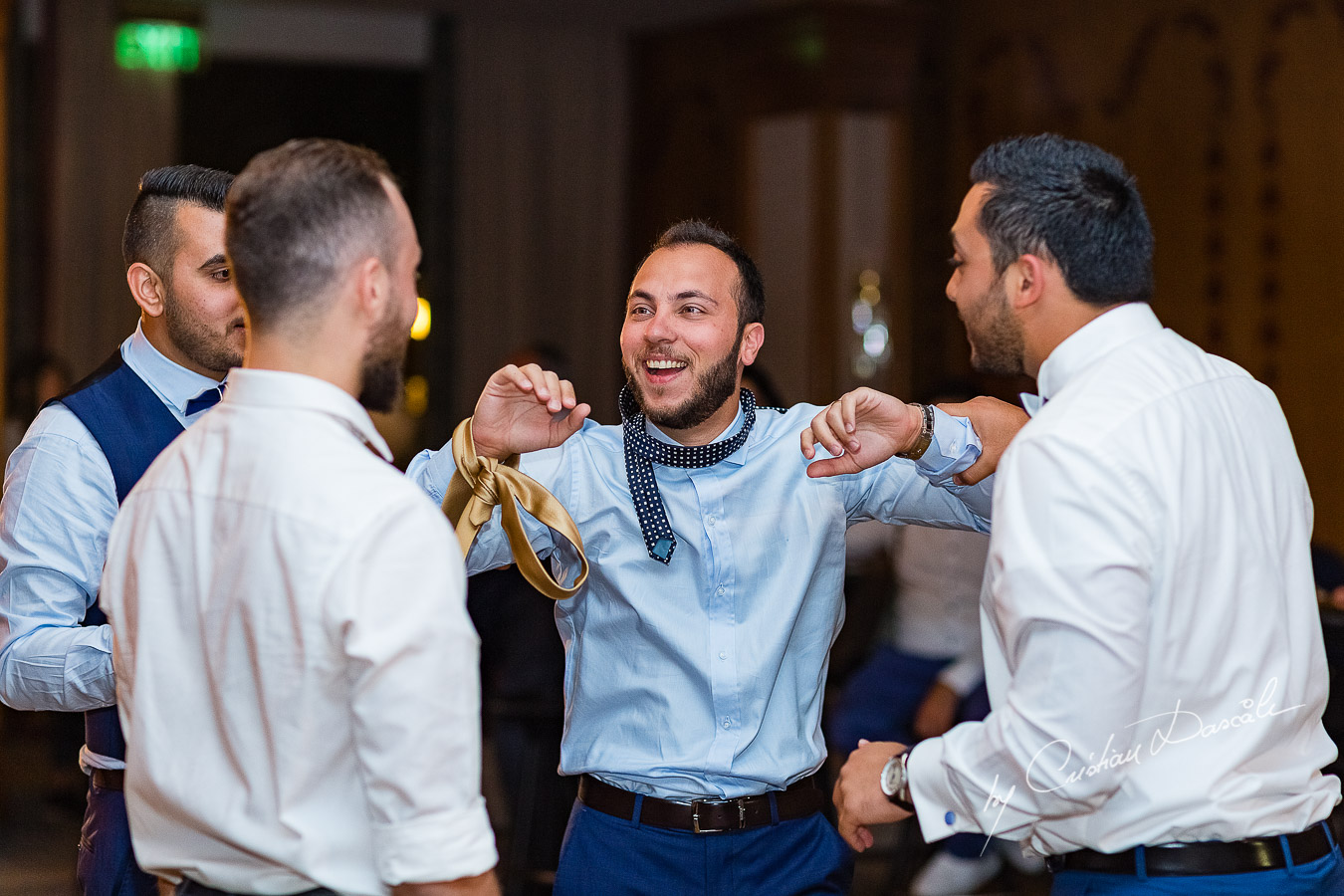 Moment when the groom is prepared for the garter photographed as part of an Exclusive Wedding photography at Grand Resort Limassol, captured by Cyprus Wedding Photographer Cristian Dascalu.