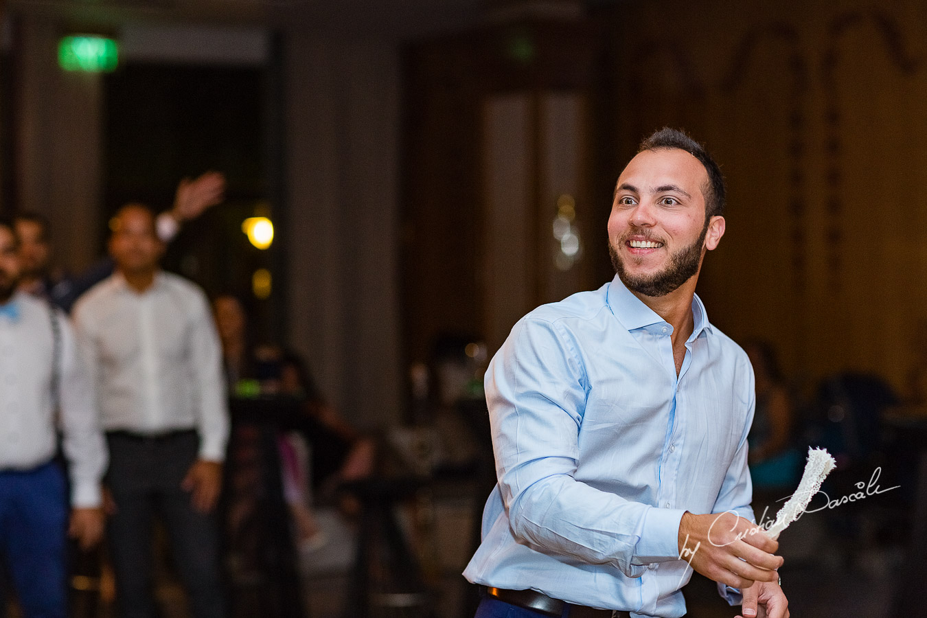Moment when the groom is throwing the garter photographed as part of an Exclusive Wedding photography at Grand Resort Limassol, captured by Cyprus Wedding Photographer Cristian Dascalu.