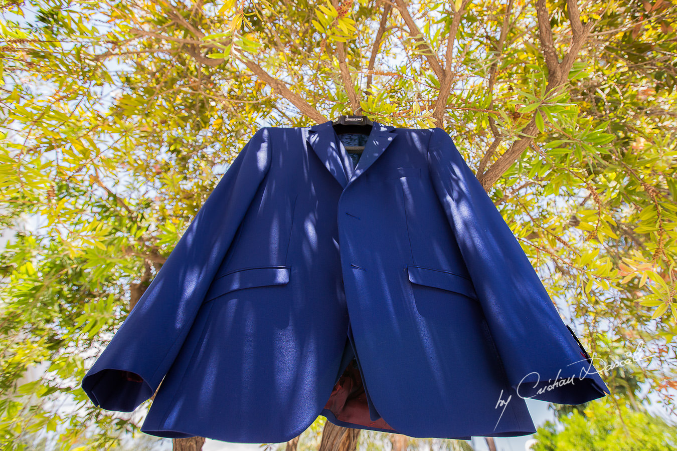 Groom's suit hanged on a tree in front of the groom's house, captured at a wedding in Cyprus by Photographer Cristian Dascalu.