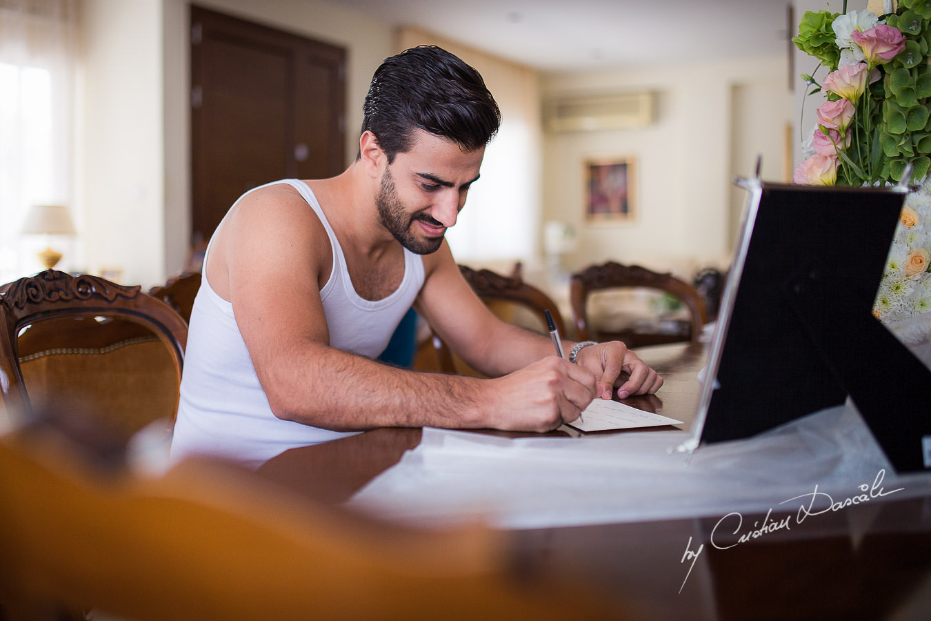 The Groom, Alexis, writing a letter to his bride, captured at a wedding in Cyprus by Photographer Cristian Dascalu.