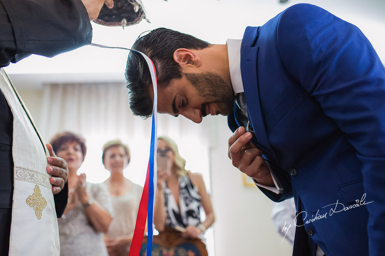 The groom making the sign of the Holy Cross during a traditional ceremony, captured at a wedding in Cyprus by Photographer Cristian Dascalu.