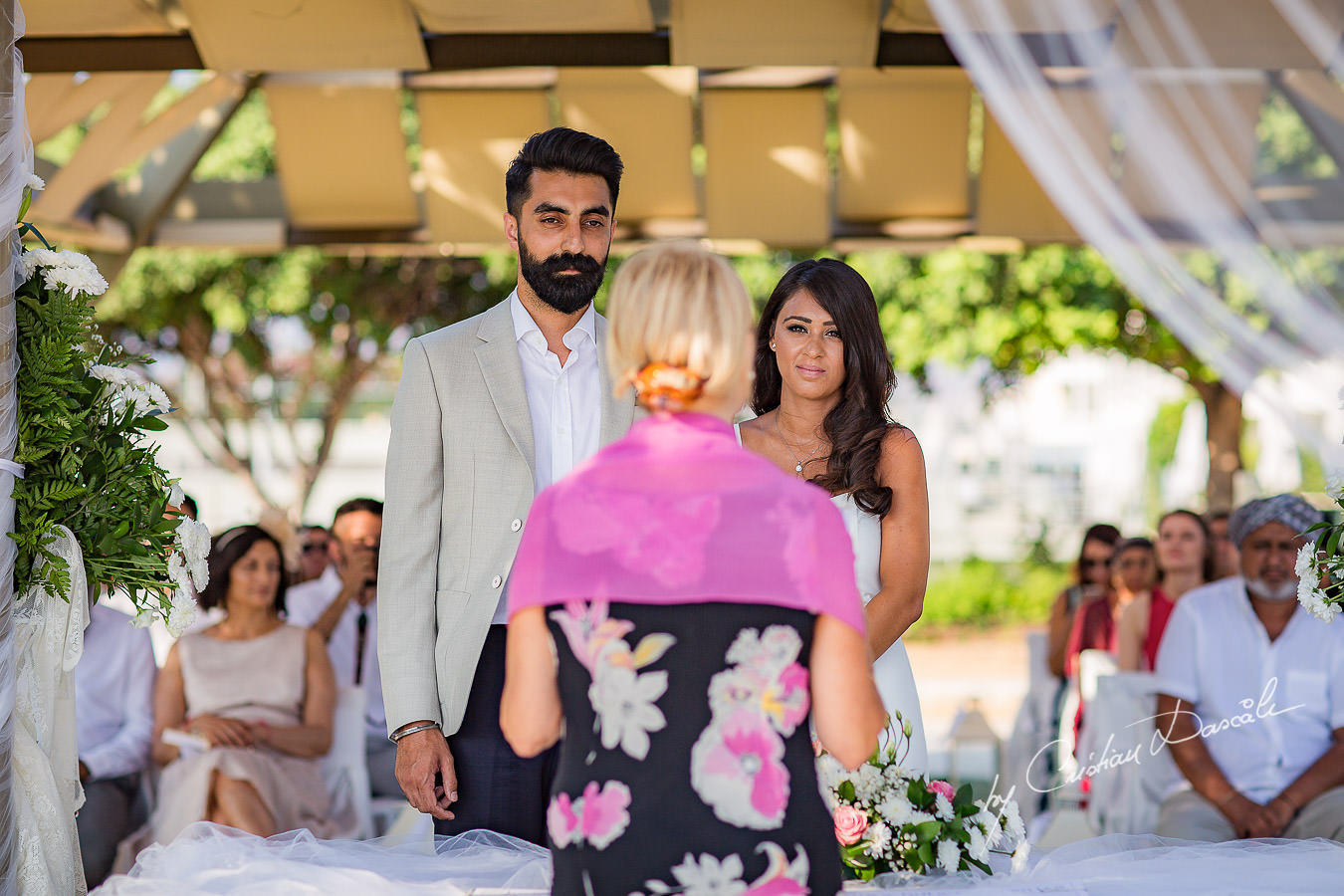 Bride and groom in front of the celebrant, moments photographed by Cristian Dascalu at Athena Beach Hotel in Paphos, Cyprus, during a symbolic wedding.