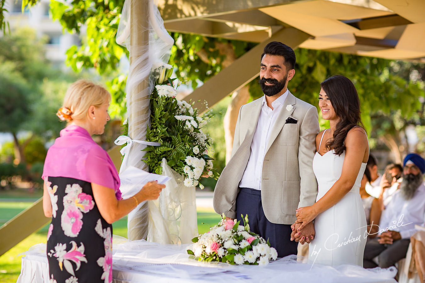 Bride and groom in front of the celebrant, moments photographed by Cristian Dascalu at Athena Beach Hotel in Paphos, Cyprus, during a symbolic wedding.