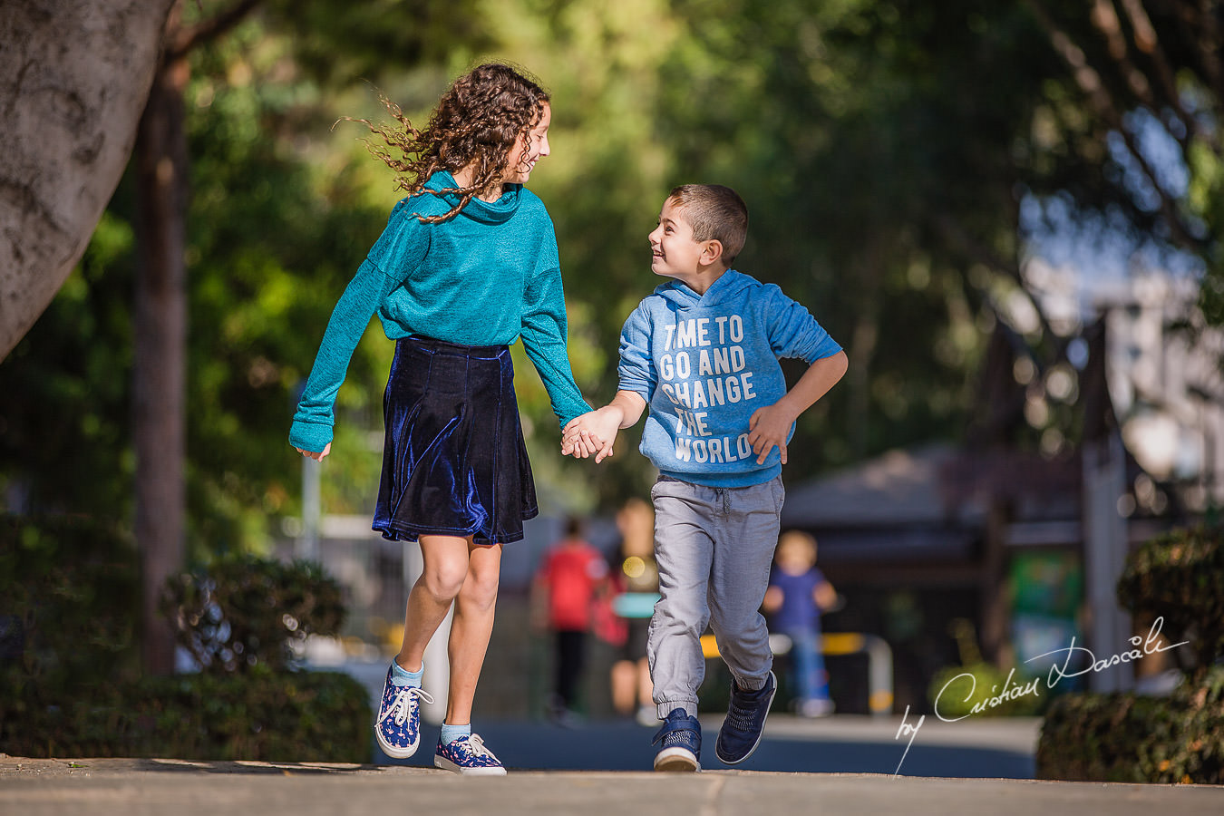 Young brother and sister running in the park, moments captured by Cristian Dascalu during a beautiful Limassol family photography photo session.