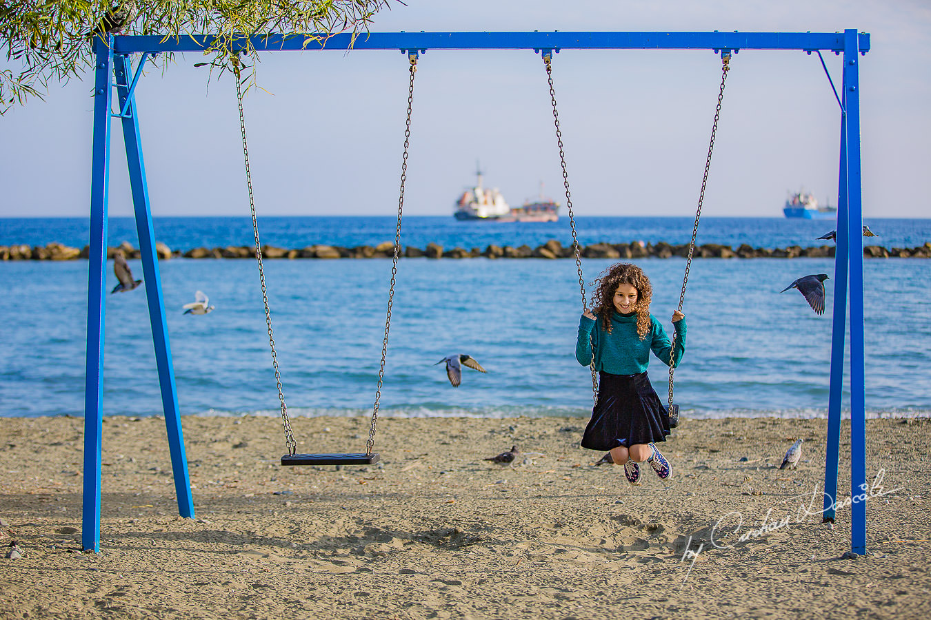 Young lady in the swing on a beach, moments captured by Cristian Dascalu during a beautiful Limassol family photography photo session.