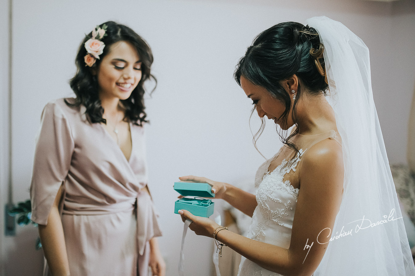 The bride Christina, opening a gift form her sister, moments captured during a wedding at St Raphael Resort in Limassol, Cyprus.