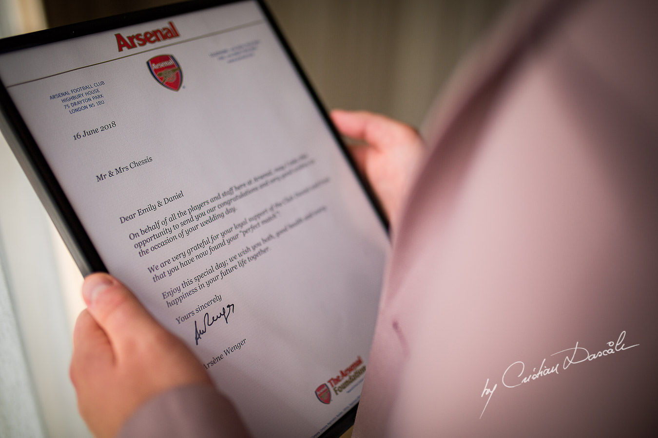 Groom reading the congratulations letter from Arsene Wenger at a Beautiful Wedding at Elias Beach Hotel captured by Cyprus Photographer Cristian Dascalu.