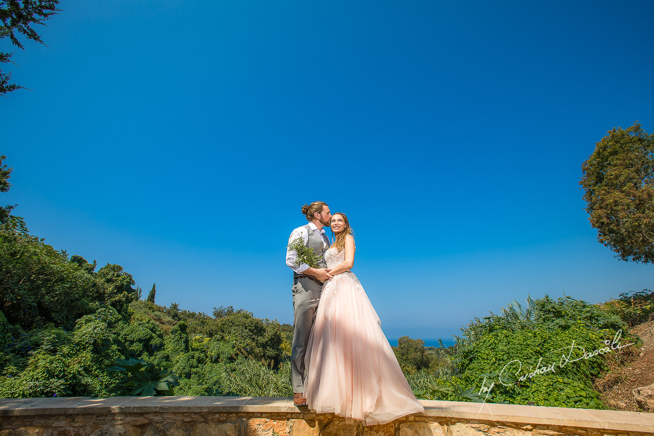 Bride and groom posing on a green garden, moments captured at a Shamanic Wedding Ceremony by Cyprus Wedding Photographer Cristian Dascalu.