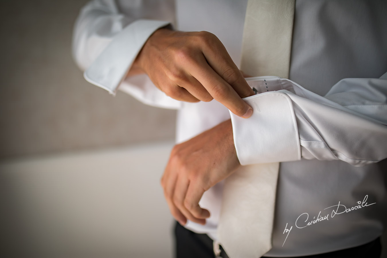 Moments when the groom is wearing his cuff links captured by Cristian Dascalu during an elegant Aphrodite Hills Wedding in Cyprus.