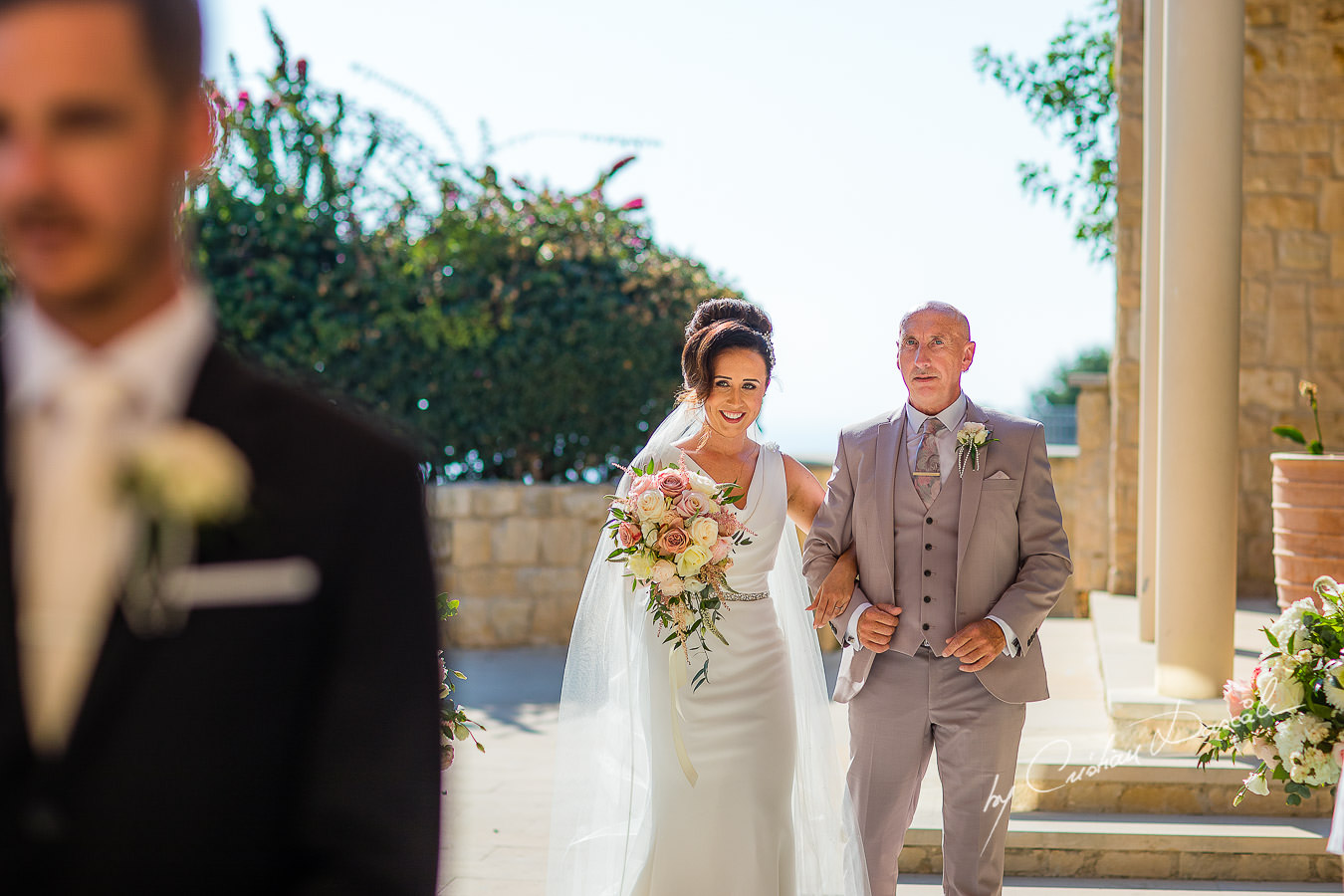 The bride is looking at her handsome groom, moments captured by Cristian Dascalu during an elegant Aphrodite Hills Wedding in Cyprus.