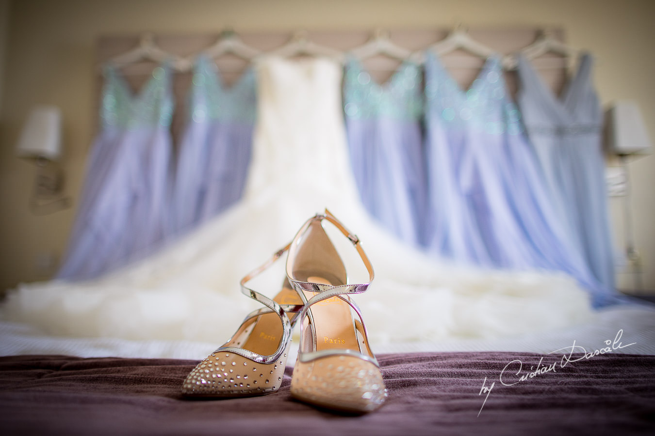 Bridal shoes with the dresses in the background, captured during an Elegant Minthis Hills Wedding, in Paphos, Cyprus.